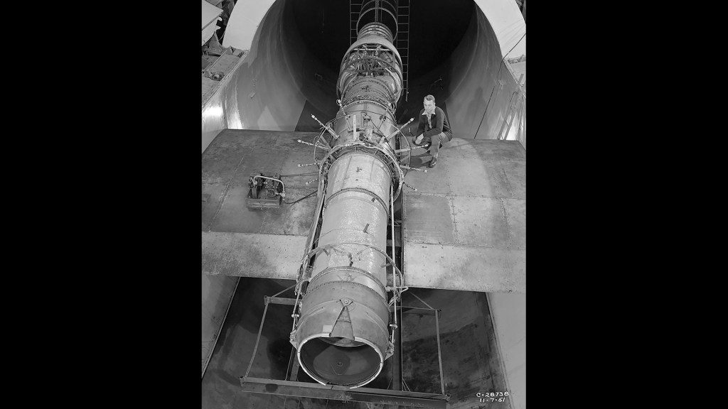 Researcher on wing span examines J40 engine in test section