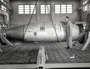 Mechanic with Allison J-71 Engine suspended by crane in AWT High-bay
