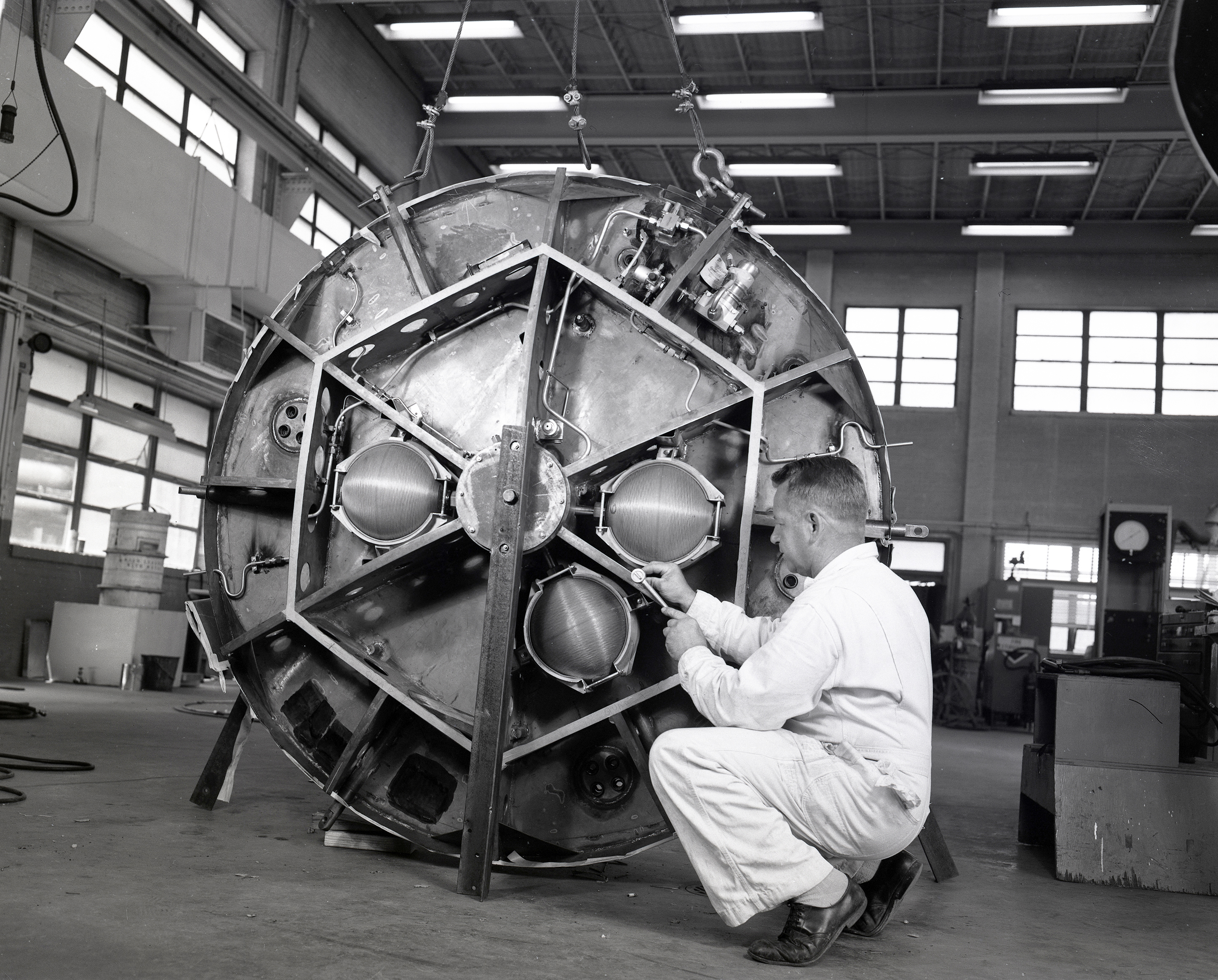 A technician working on control package of a Mercury capsule in shop