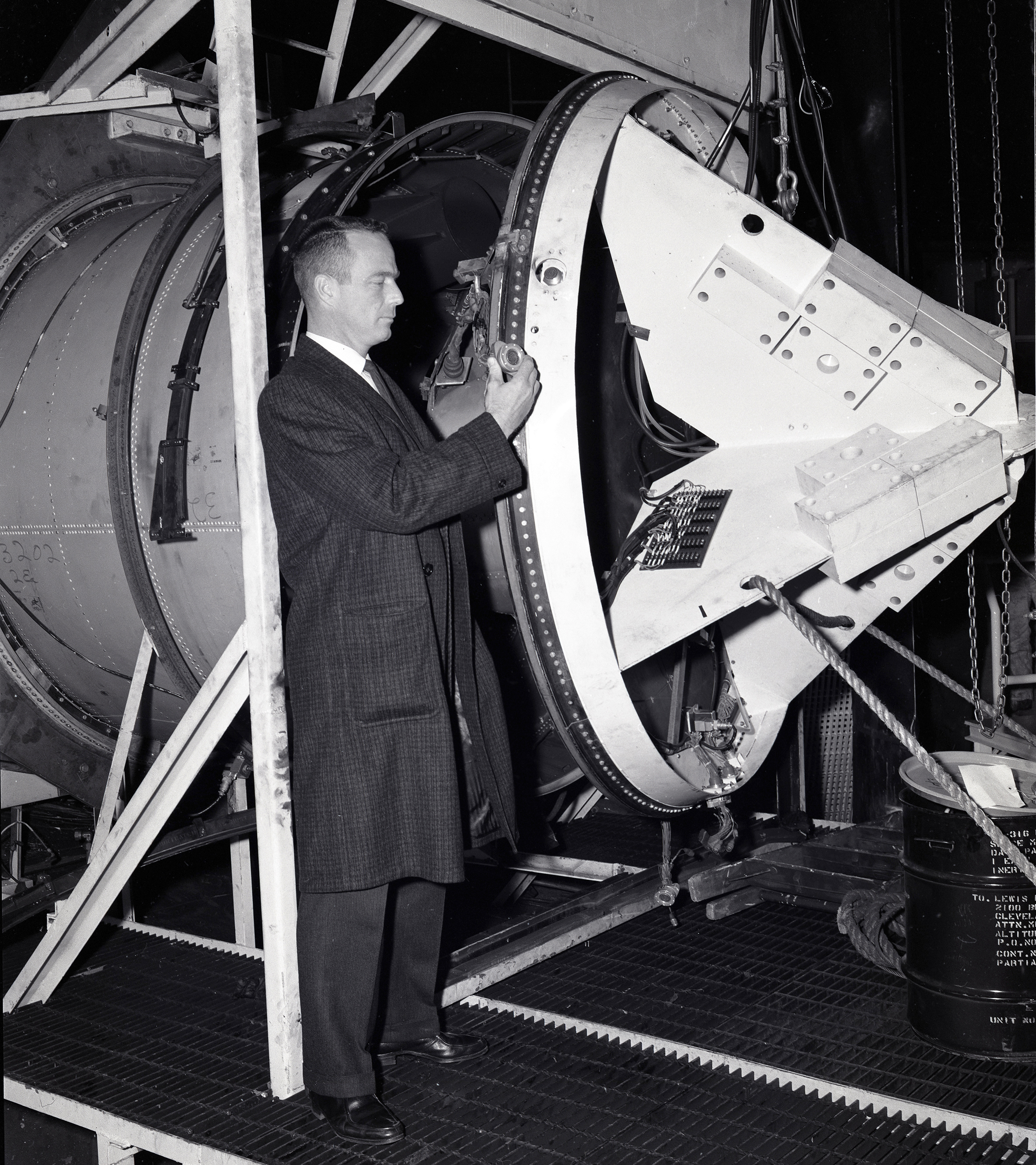 Scott Carpenter examining setup for capsule separation tests.