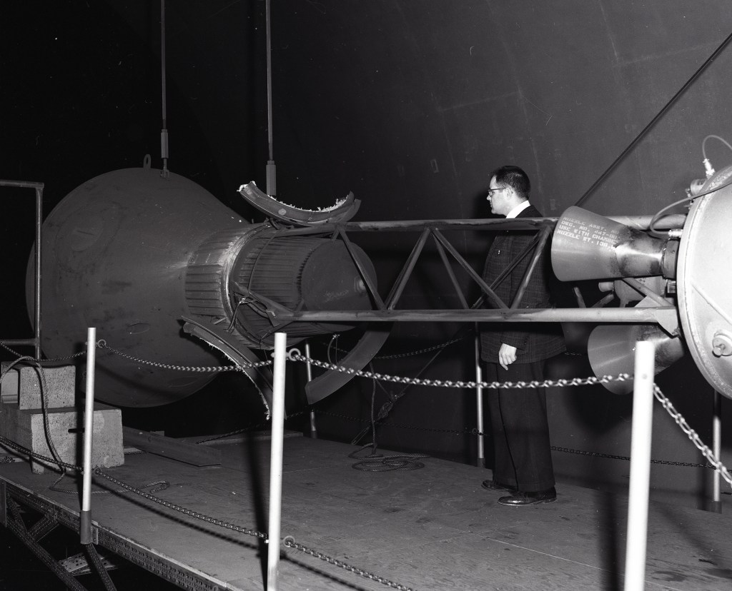 Researcher examines setup for Mercury capsule escape rocket test