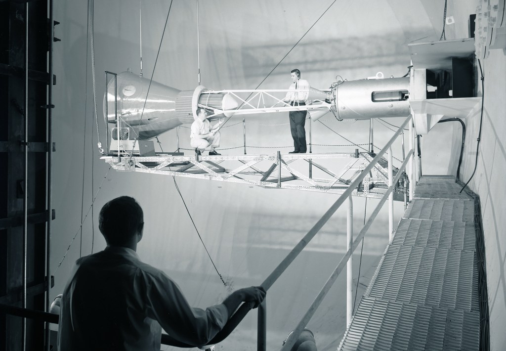 Men on catwalks viewing Mercury capsule.
