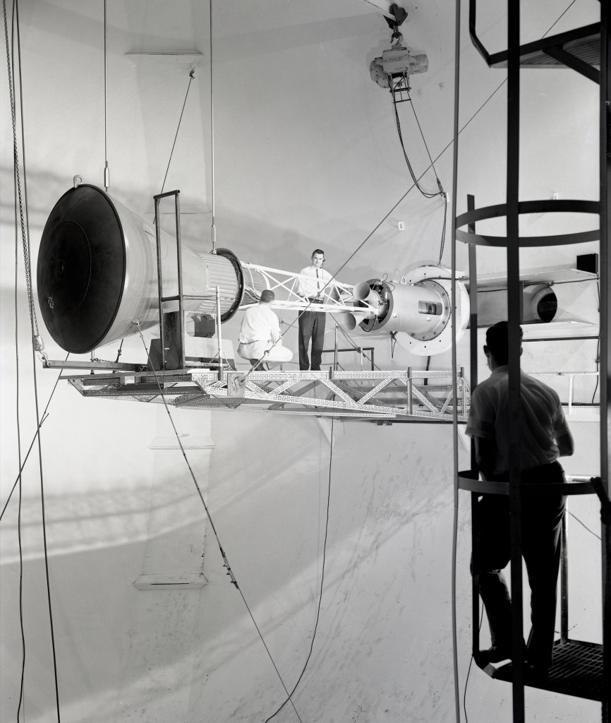 Engineers on platform work on capsule mounted on tunnel wall