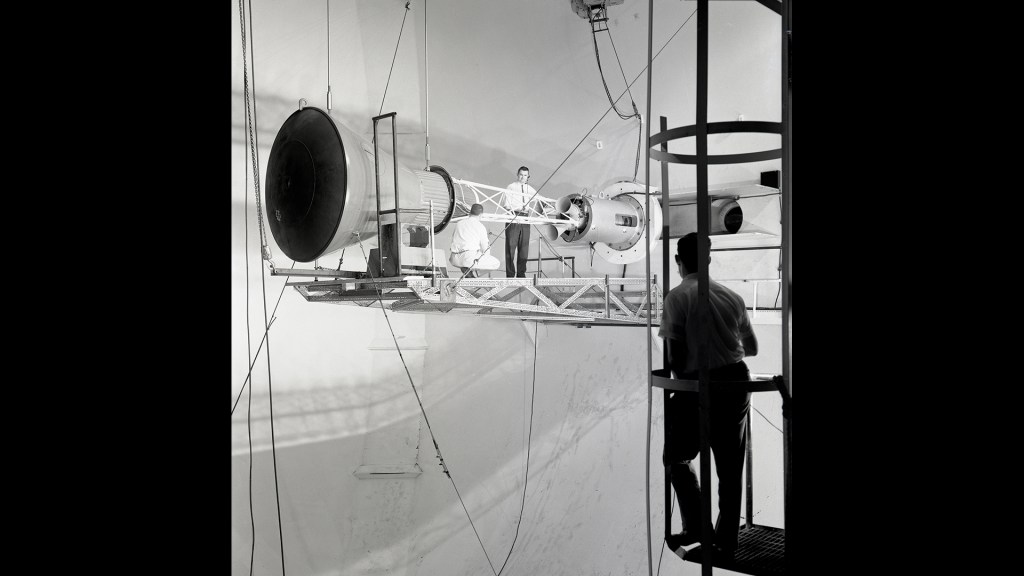 Engineers on platform work on capsule mounted on tunnel wall