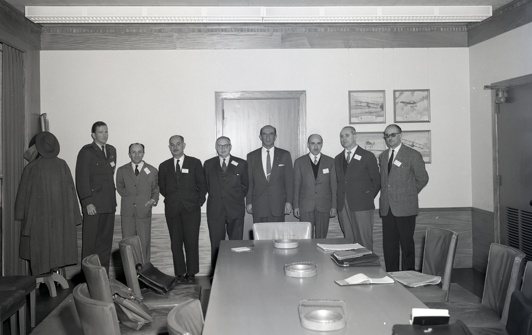 Group of men standing at end of table.