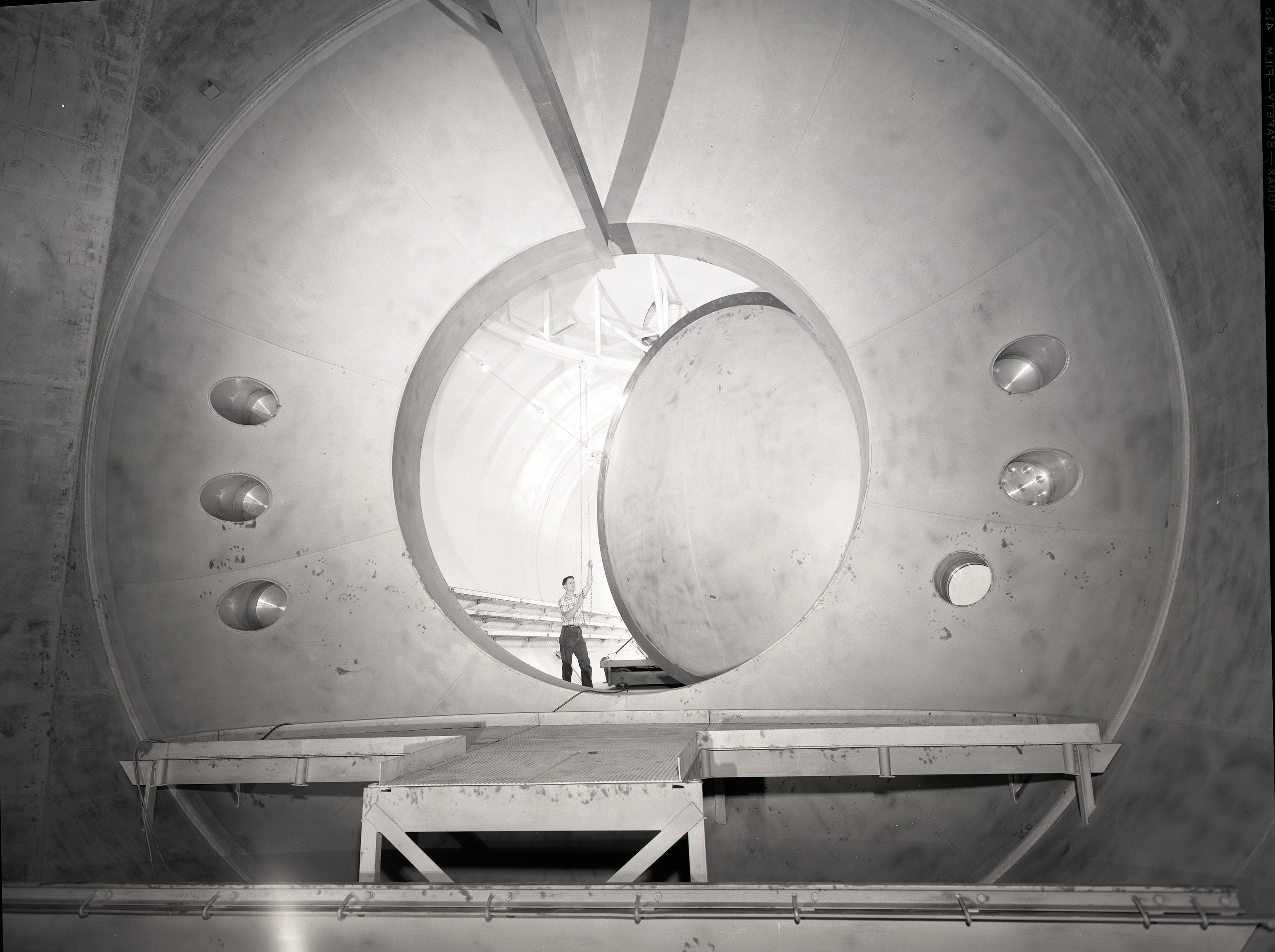 Man standing in large oval doorway.