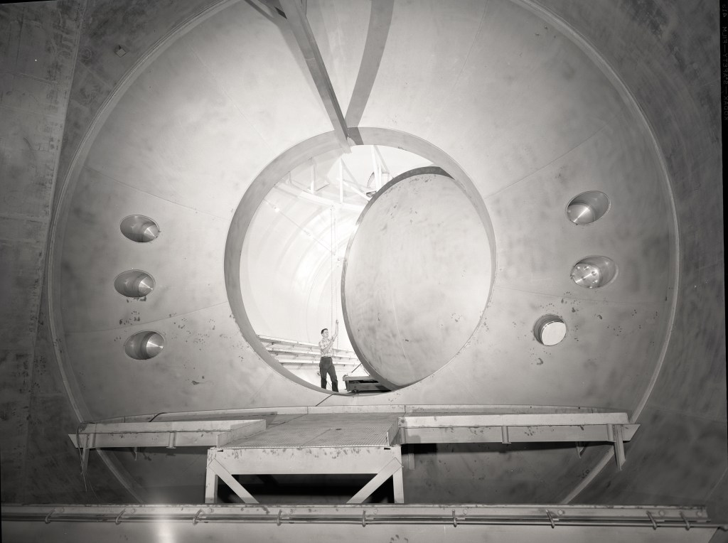 Man standing in large oval doorway.
