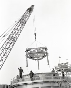Crane lowering stand into test chamber.