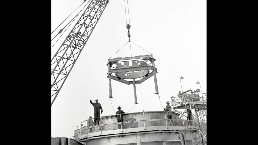 Crane lowering stand into test chamber.