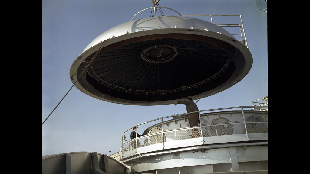 Crane lifting dome from chamber.