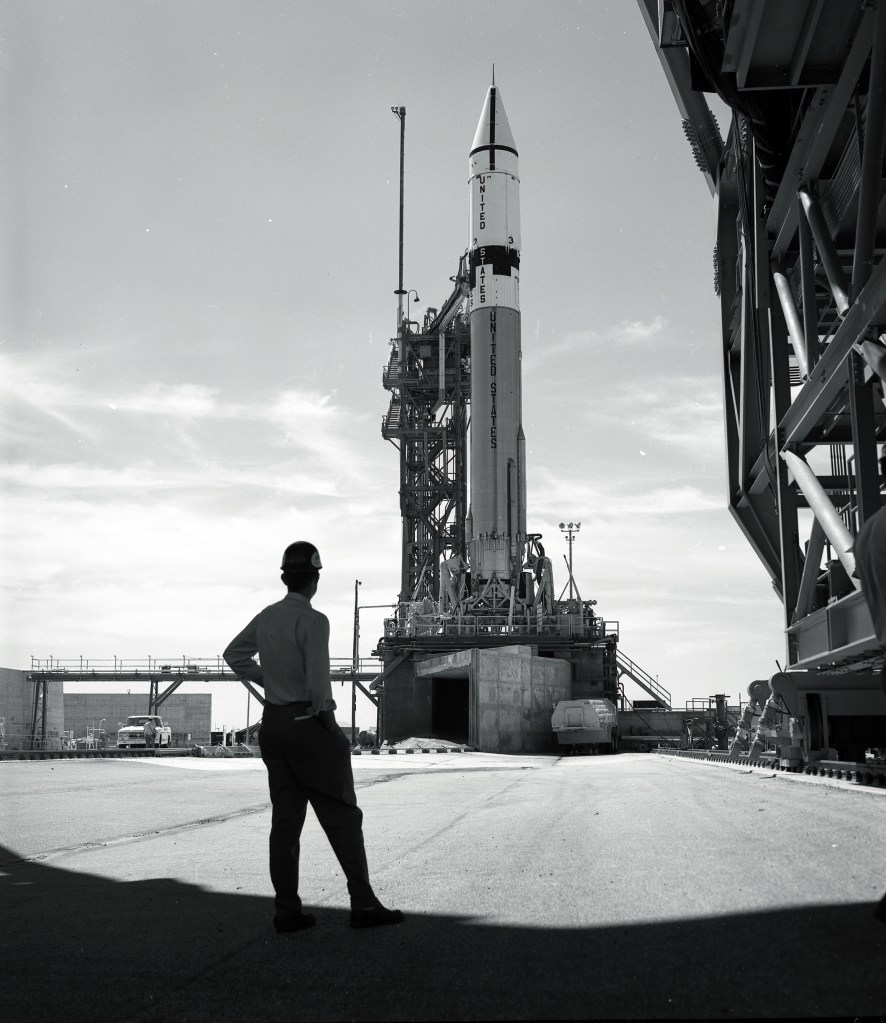 Man looking at rocket on launch pad.