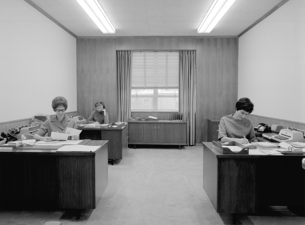 Three women sitting at office desks.