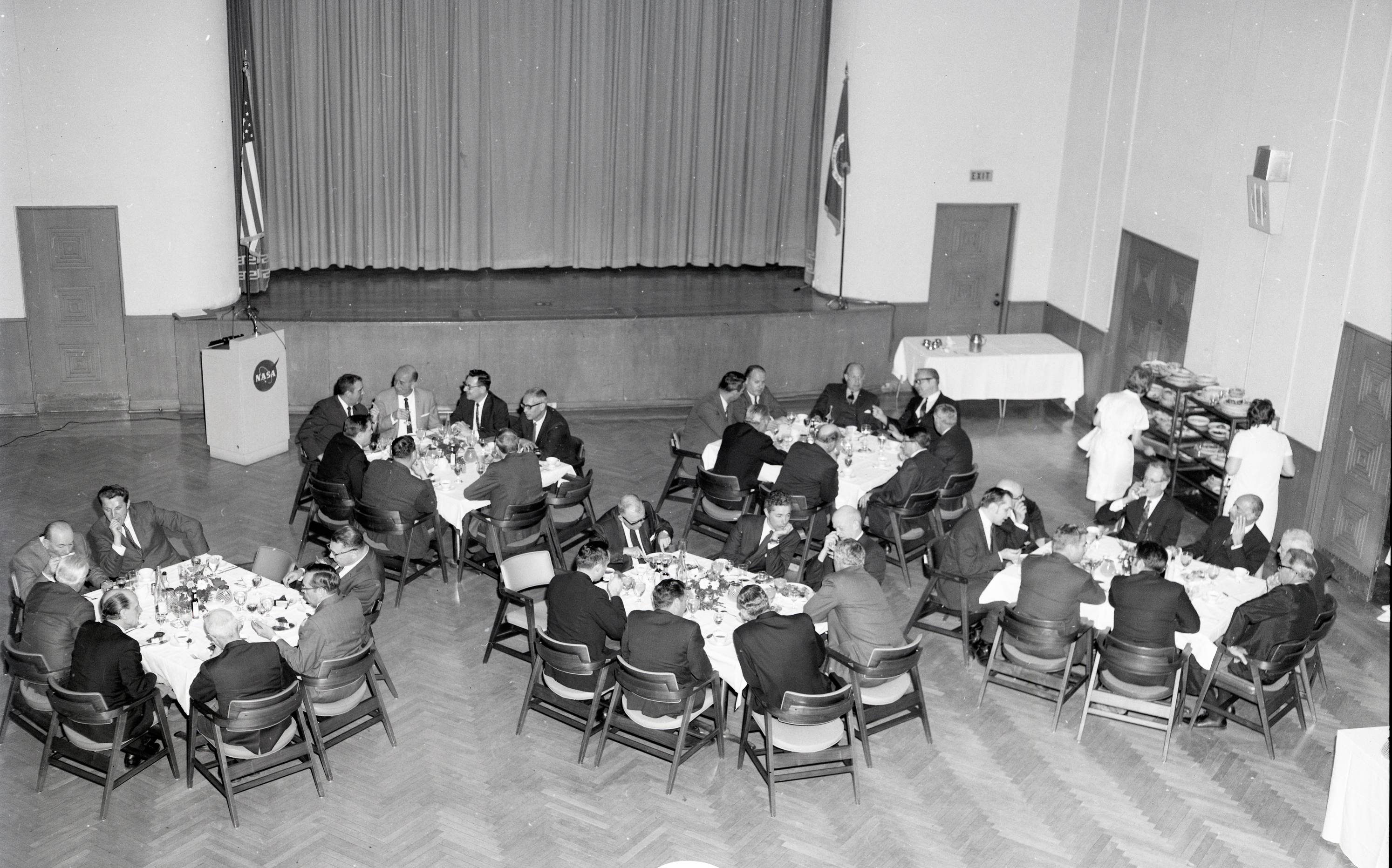 View from above of people at tables in auditorium.