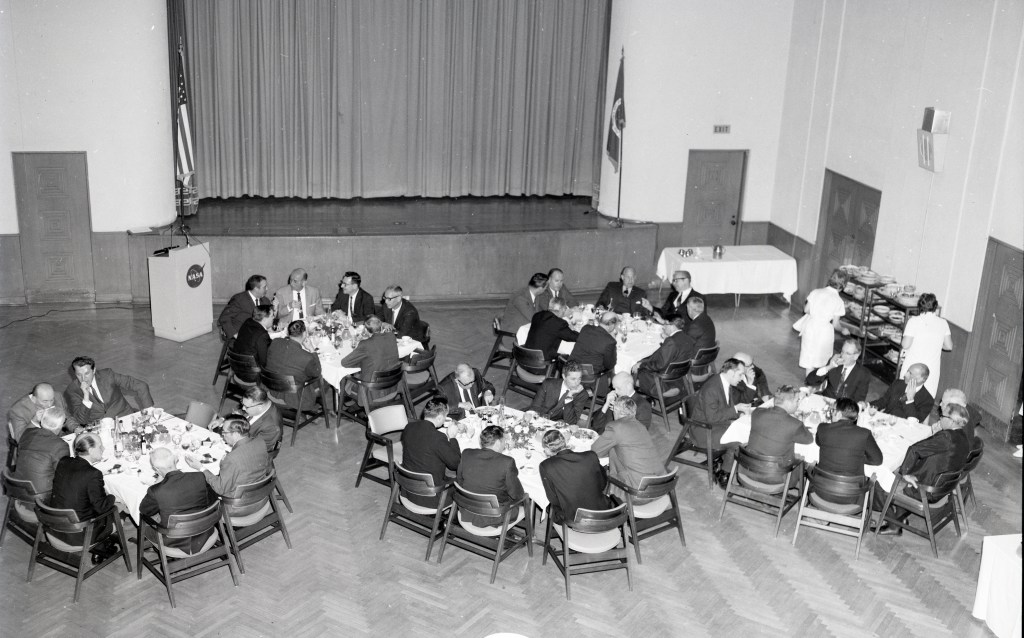 View from above of people at tables in auditorium.