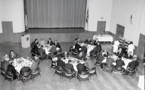 View from above of people at tables in auditorium.