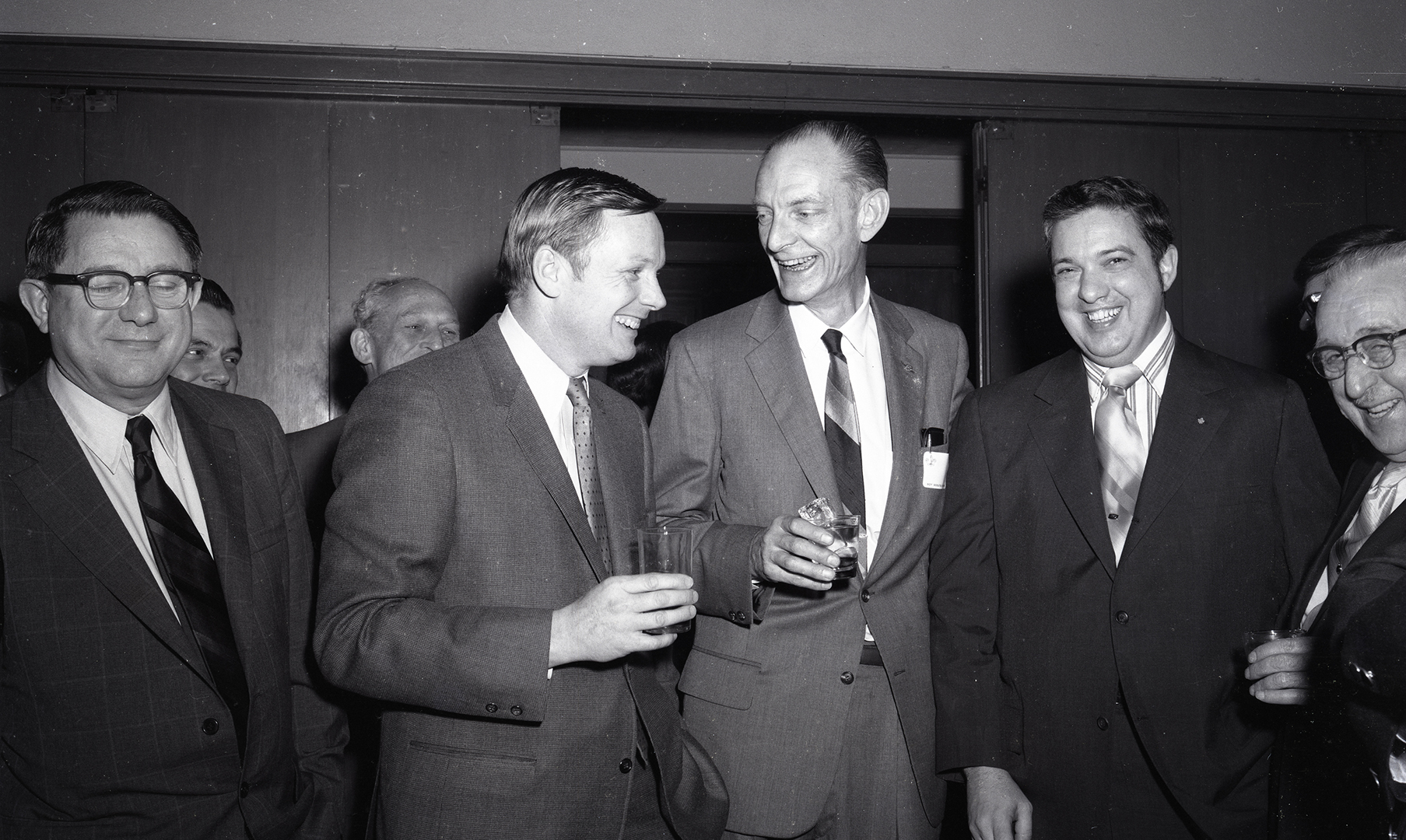 Men greeting one another in auditorium.