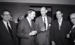 Men greeting one another in auditorium.