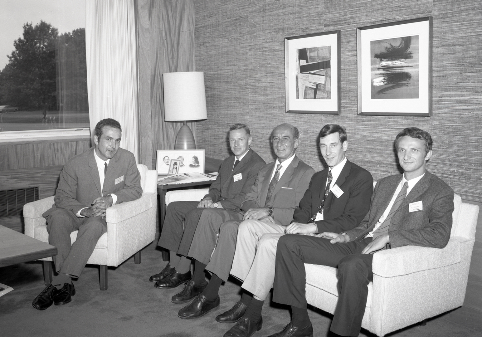Men sitting on sofa in office.