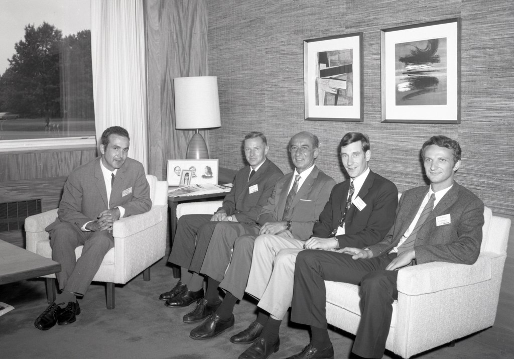 Men sitting on sofa in office.