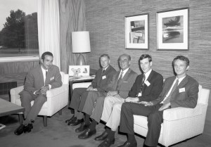 Men sitting on sofa in office.