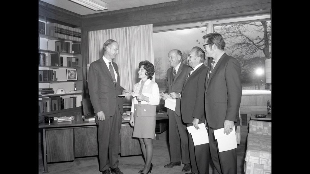 Group of people standing in office.