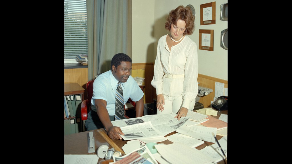 Man and woman at desk reading documents.