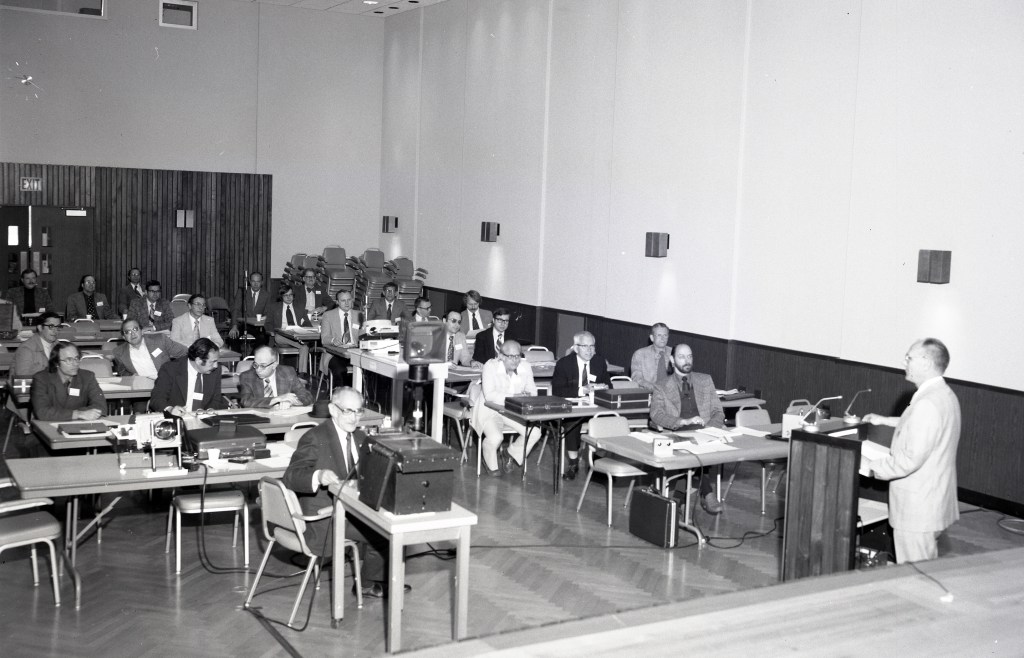 People listening to presentation in auditorium.