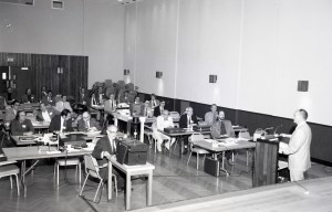 People listening to presentation in auditorium.