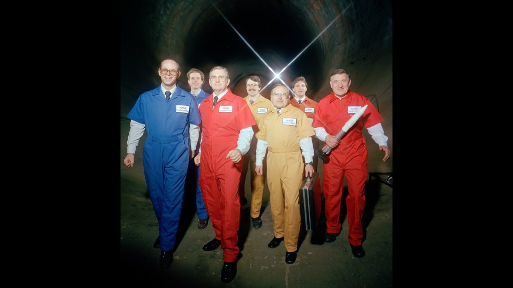 Members of AWT team in jumpsuits superimposed of interior shot of the tunnel