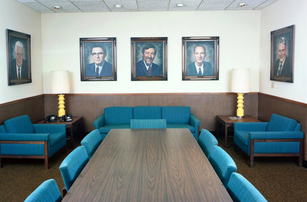 Empty conference room with portraits on wall.