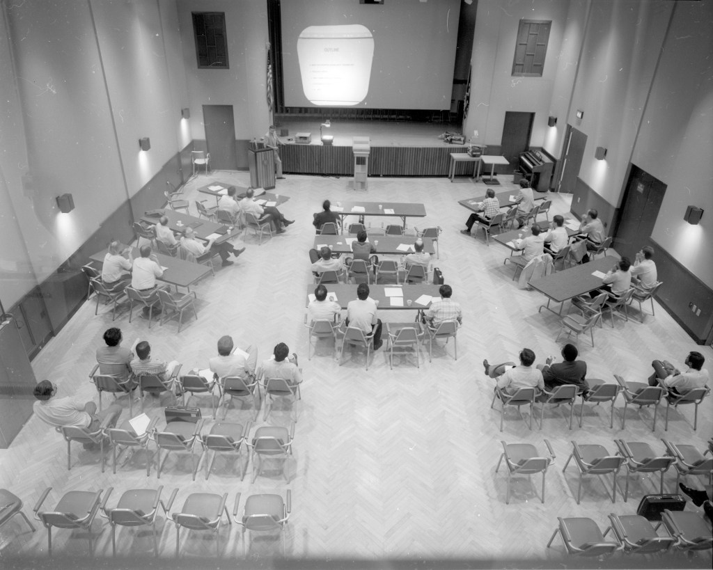 View from above of people at tables in auditorium.