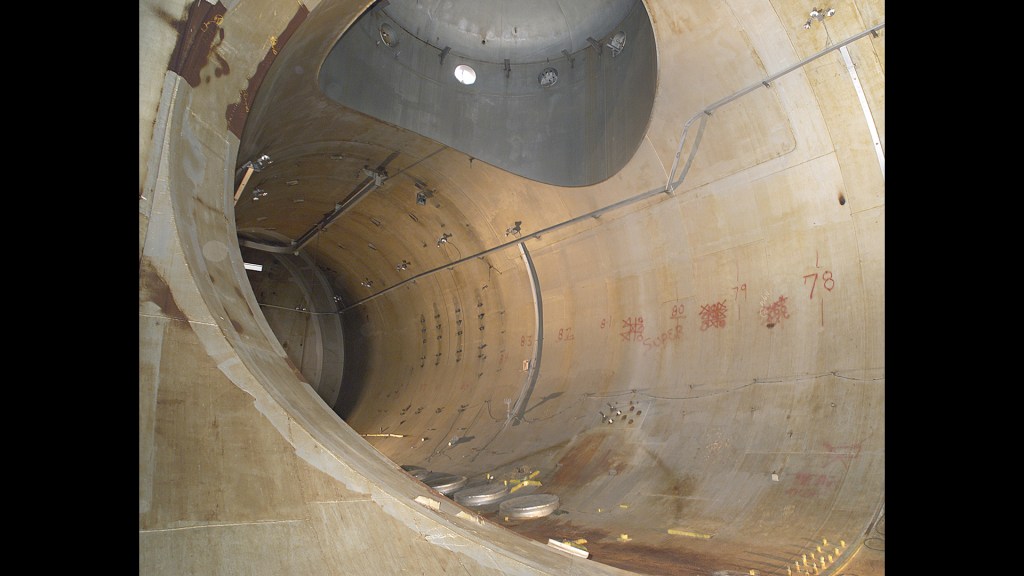 Rusting interior of large chamber.