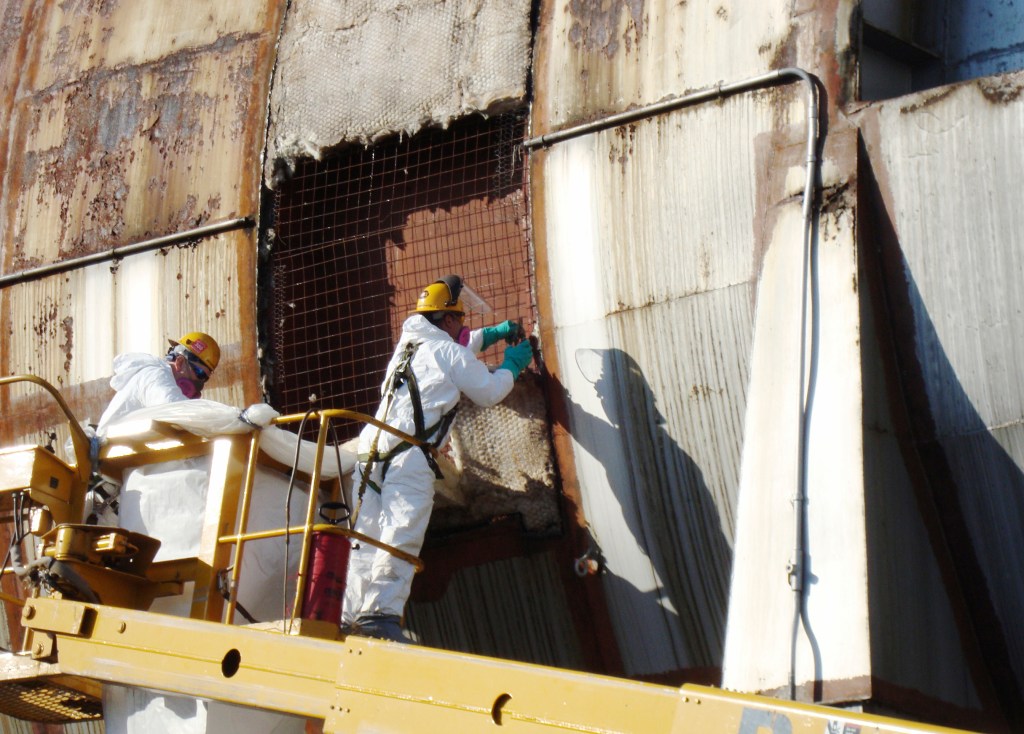 Two men in lift removing section of tunnel shell