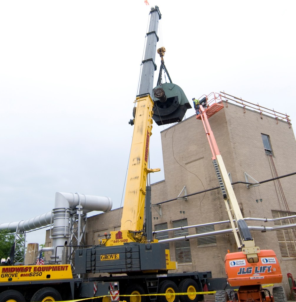 Crane lifts drive motor from roof of Exhauster Building