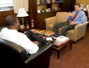 Two men sitting in chairs talking.