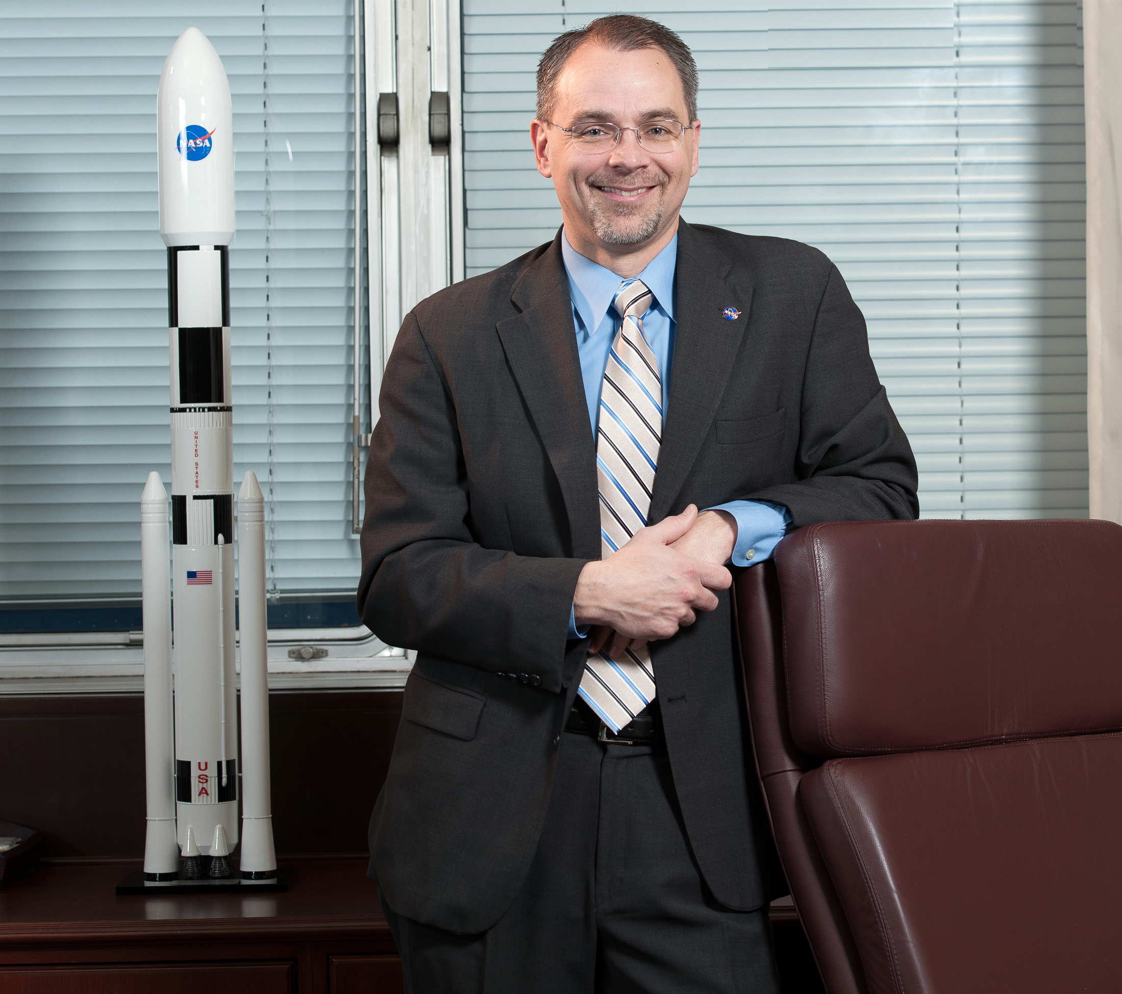 Man in suit with rocket model.