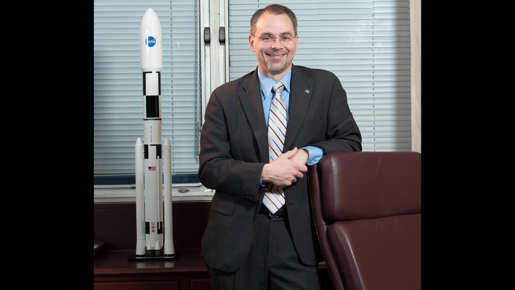 Man in suit with rocket model.