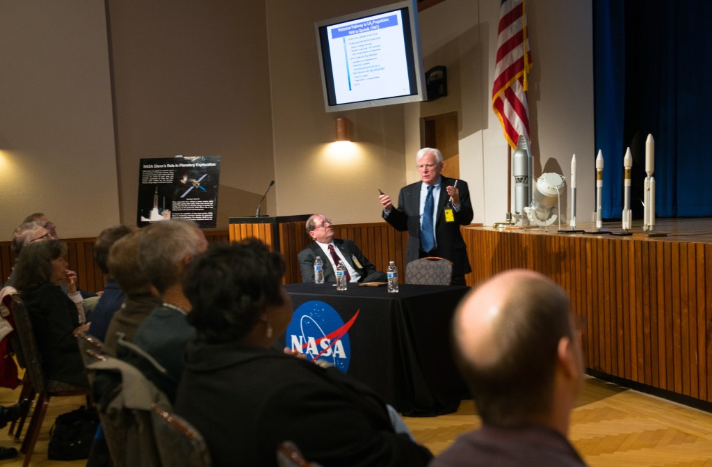 Two men at podium talking in auditorium.