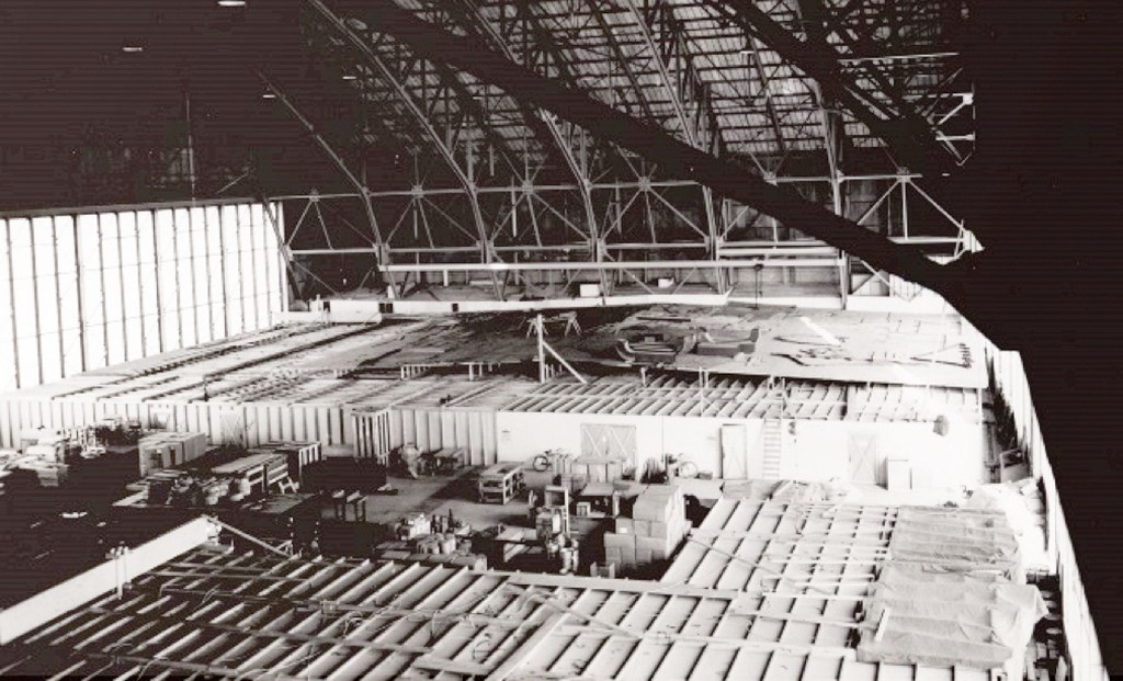 View of small structures inside hangar.