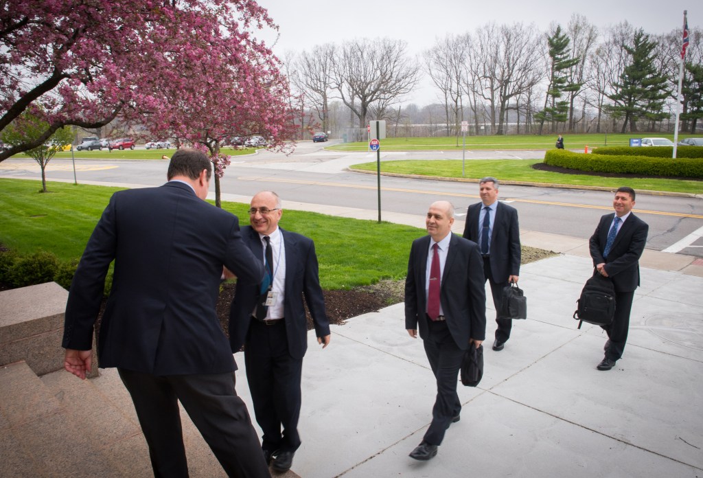 Men shaking hands on building front steps.