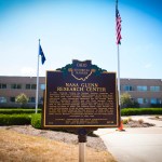 Historical marker with building behind.