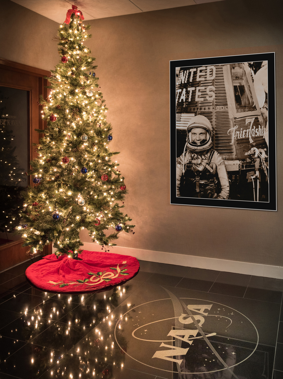 Christmas tree next to John Glenn poster.