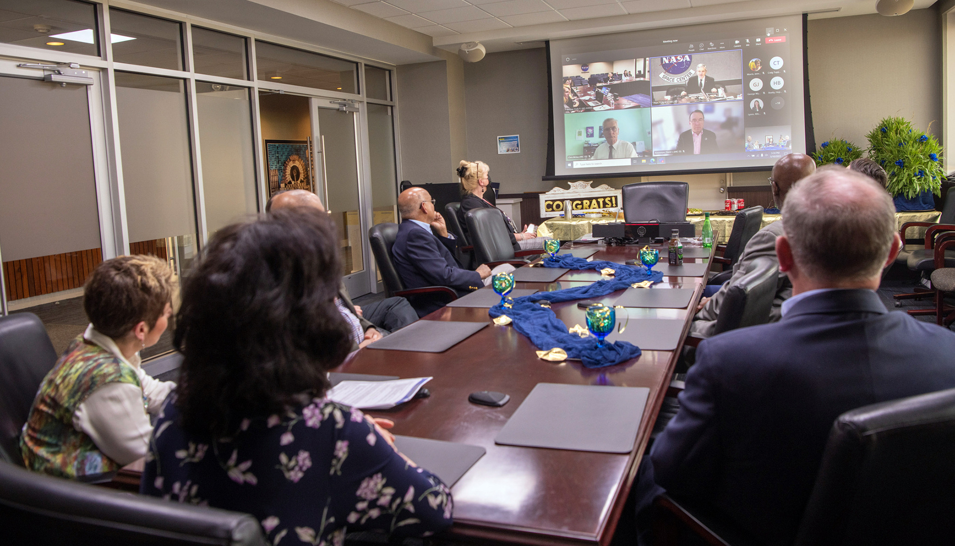 People in conference room watching screen.