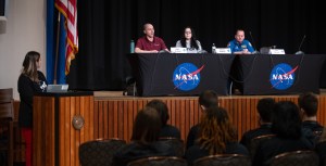 Panel of students on stage.