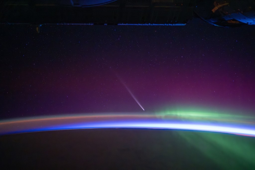 Comet rises up over the horizon just before orbital sunrise with aurora streaking by.