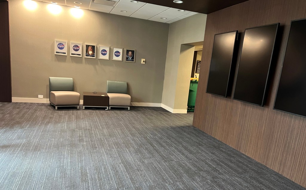 Empty lobby with hanging video screens.