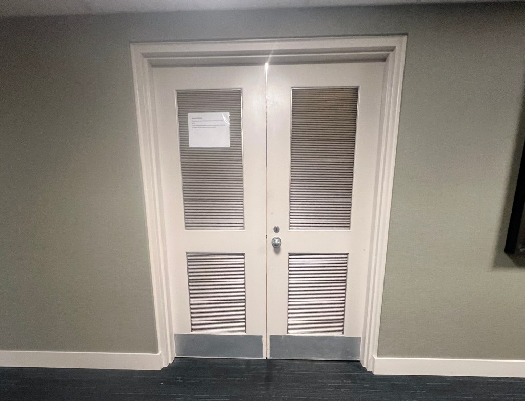 Two closed doors with vents.