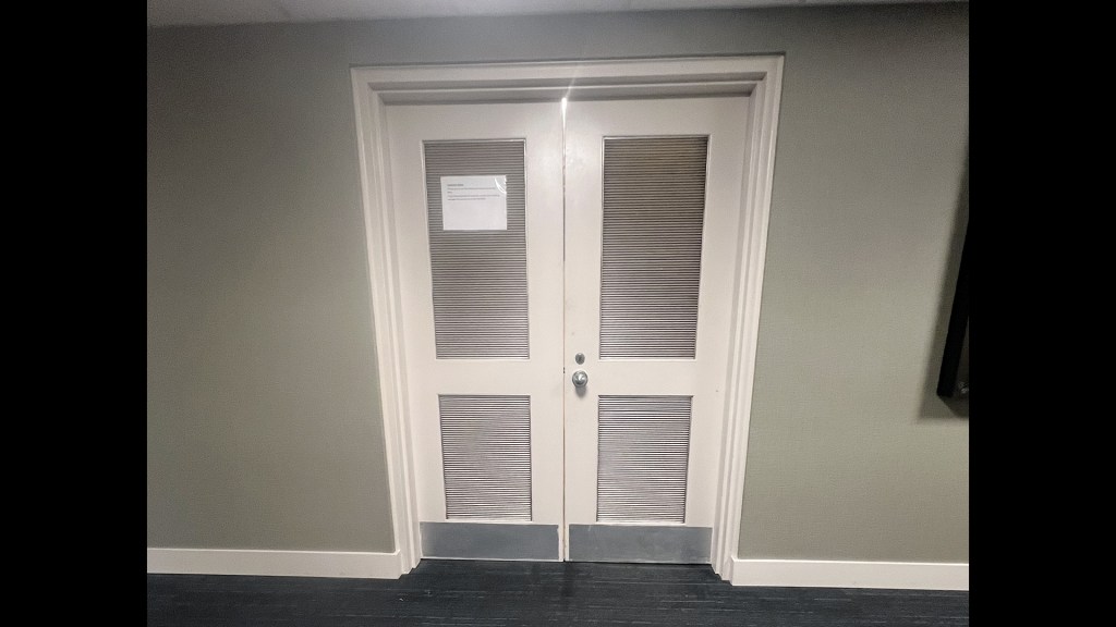 Two closed doors with vents.