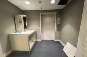 View of elevator entrance and table in hallway.