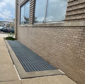 Grated area next to building.